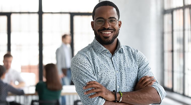 A workplace leader smiles after successfully navigating uncertainty. 