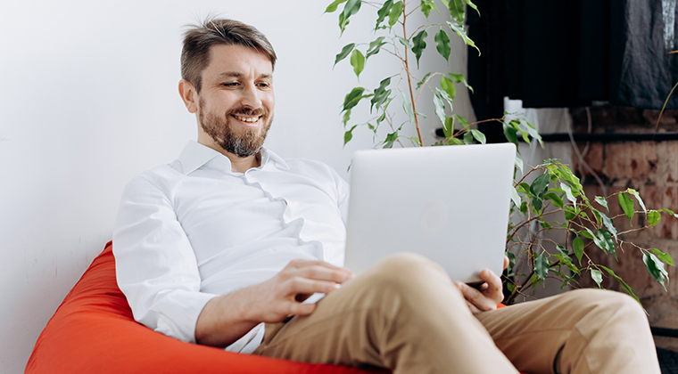 Employee sitting on bean bag chair with laptop