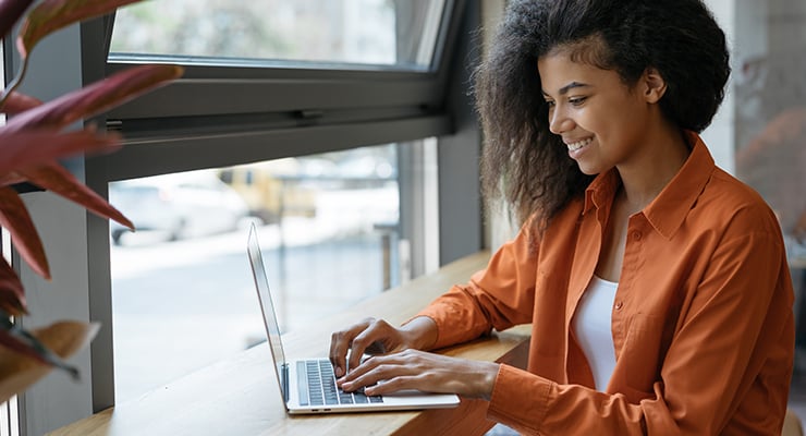 Remote employee works on a laptop from a coffee shop