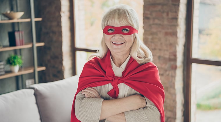 Mature woman wearing mask and a cape