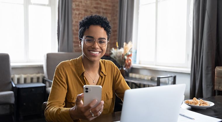 A woman at her computer smiles at how HR tech has transformed the vertical SaaS platform she works for. 