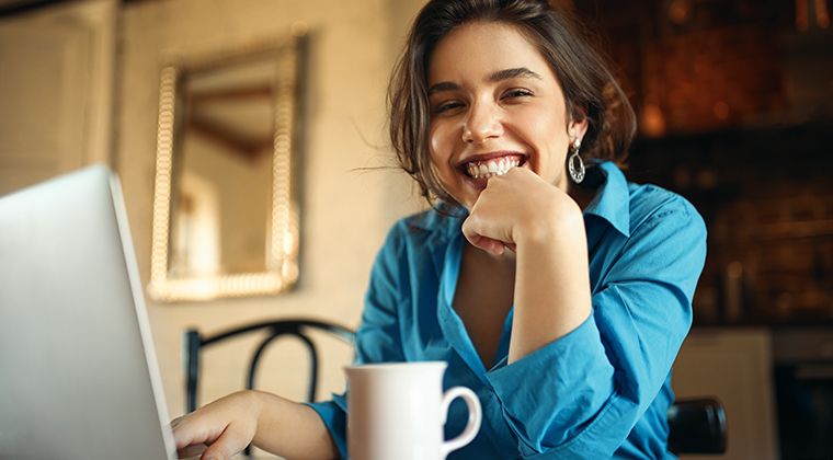 Smiling woman working remotely on laptop