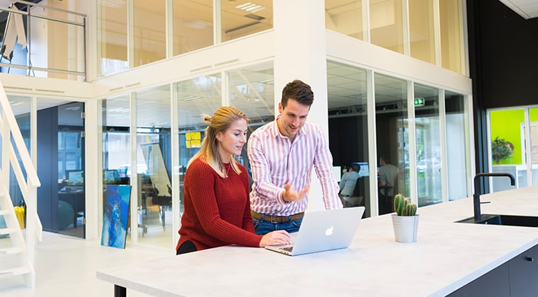 Co-workers reviewing LinkedIn account for optimization