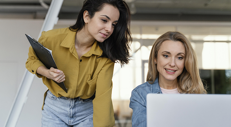 Two co-workers evaluate a private label applicant tracking system on a laptop