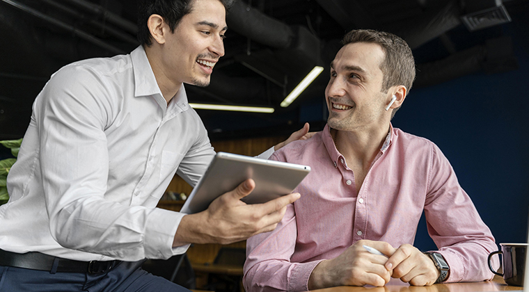 Two coworkers reviewing stats on recent applicants.