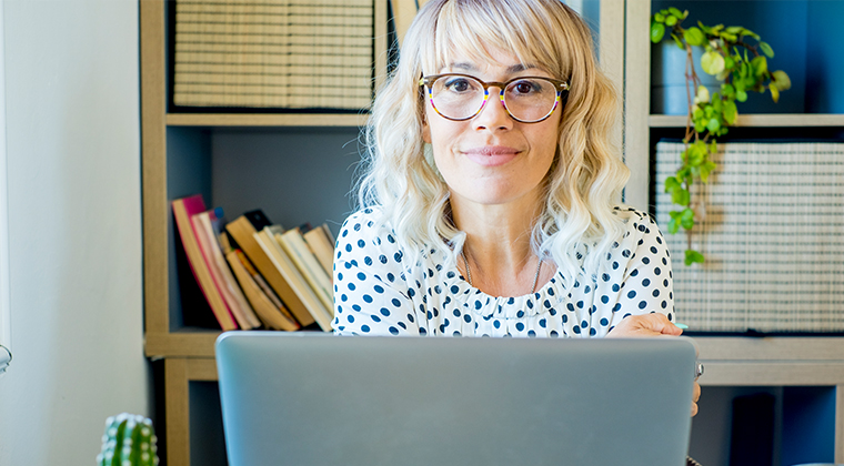 Woman with glasses working at home in organized office